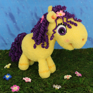 Фиалочка, маленькая пони гуляет по траве и украшает голову цветами