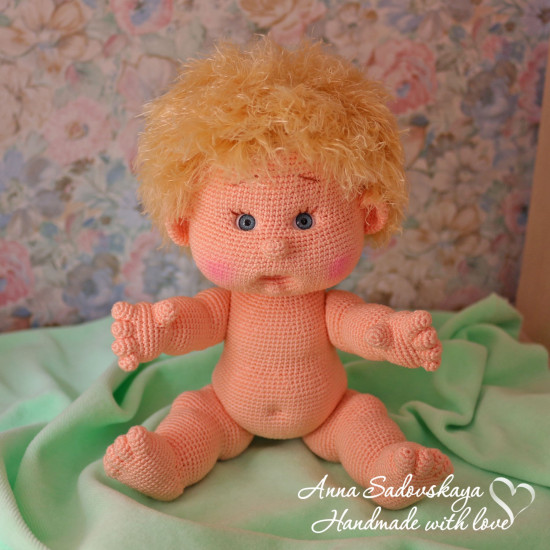 Вязаный пупсик позирует для фото